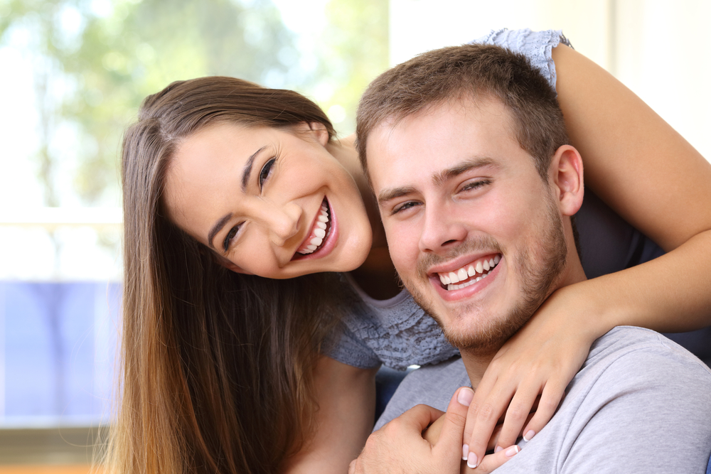 Three women smiling together representing confidence, joy, and positive dental experiences – dentist williamsville ny