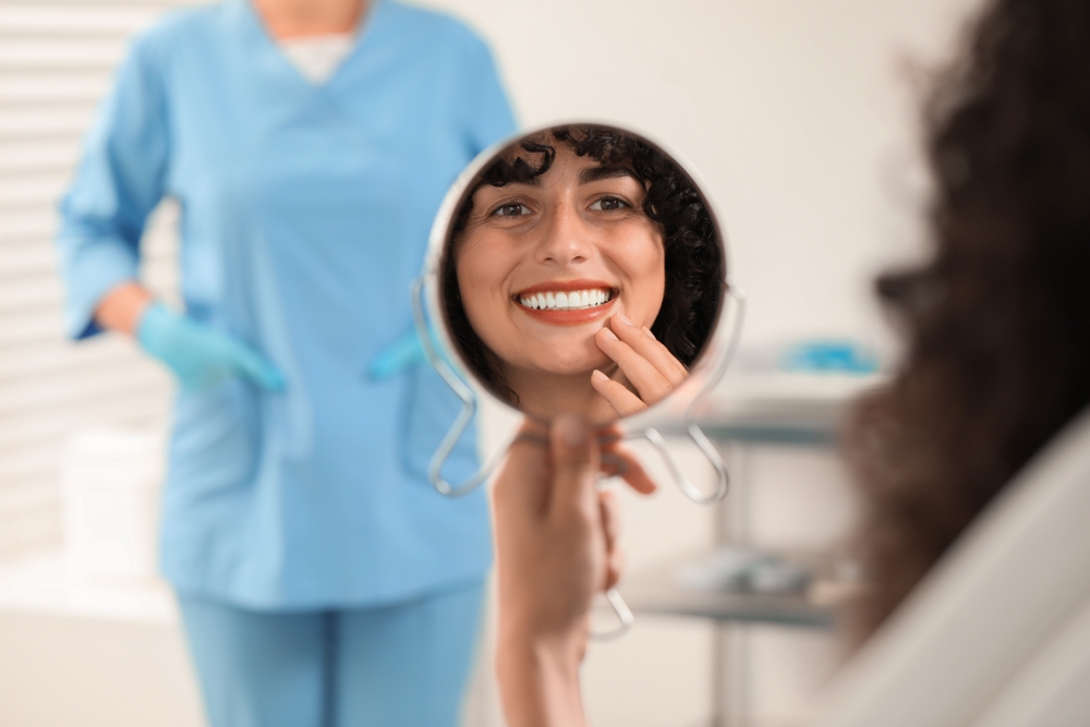 Three women smiling together representing confidence, joy, and positive dental experiences – dentist williamsville ny